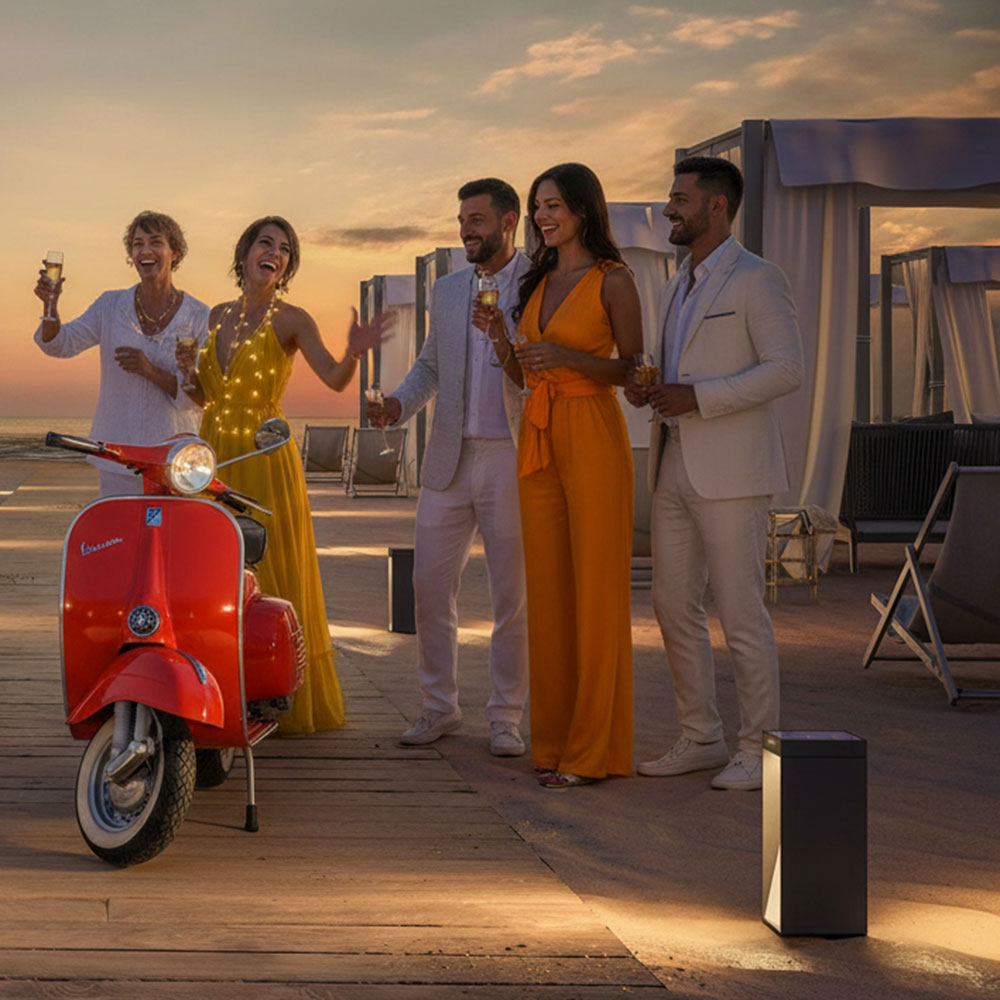 Eine Gruppe gut gekleideter Italiener steht am Strand - im Vordergrund steht eine autonome Design-Solarleuchte